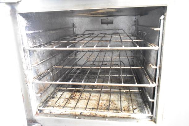 Lang RTI36E commercial induction range interior, showing metal racks and signs of use. 208/240V, 3 phase electric unit.