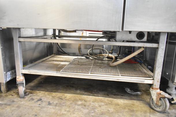 Blodgett 102/BCM2.10 commercial gas combi convection oven on casters, visible lower storage rack and wiring, stainless steel exterior.