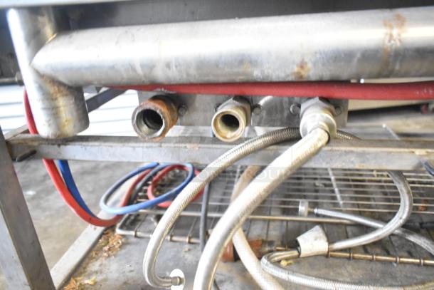 Blodgett 102/BCM2.10 commercial gas combi oven underside, showing gas and water connections with metal casing and casters.