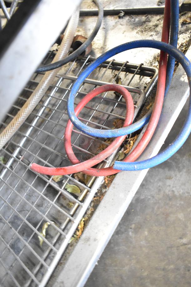 Red and blue wires next to metal grid in a commercial kitchen setting. Visible dirt and debris suggest used condition.