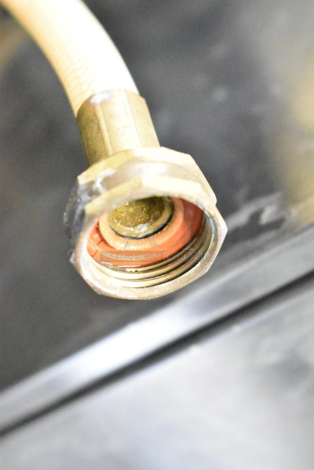 Close-up of a hose fitting on the Electro Freeze 88T-RMT-137 soft serve machine. Metal and plastic components visible.