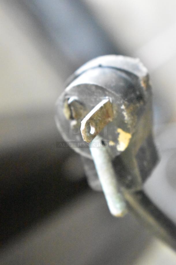 Close-up of a power plug for the Beverage Air MT38 Commercial 2 Door Cooler, 115 volts, 1 phase, showing wear.
