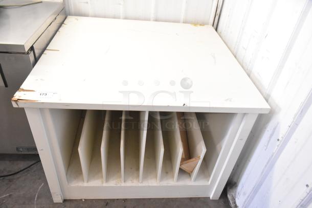 White counter with divided storage slots below. Visible wear on edges. Tag reads "173 QTY." Suitable for organizing.