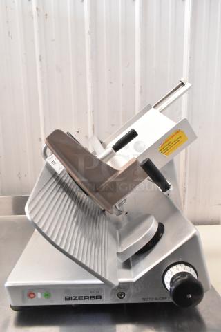 Bizerba commercial countertop meat slicer, model SE 12, 120 volts, 1 phase, with adjustable slicing knob and visible caution sticker.