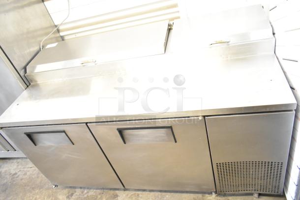 True TPP-67 commercial pizza prep table with stainless steel finish, two doors, and refrigeration unit on casters. 115V, 1 phase.