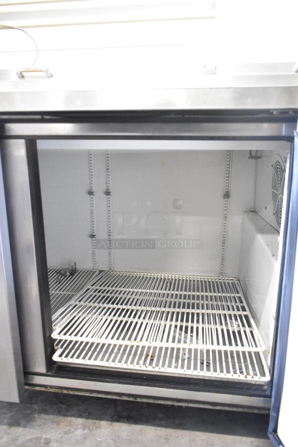 True TPP-67 commercial pizza prep table with stainless steel top and wire shelving, on commercial casters; 115 volts, 1 phase.