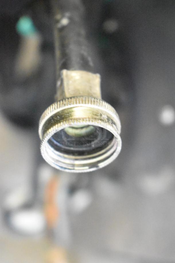 Close-up of a metallic connector on a Taylor C712-33 soft serve machine, showcasing part of its water cooling system.