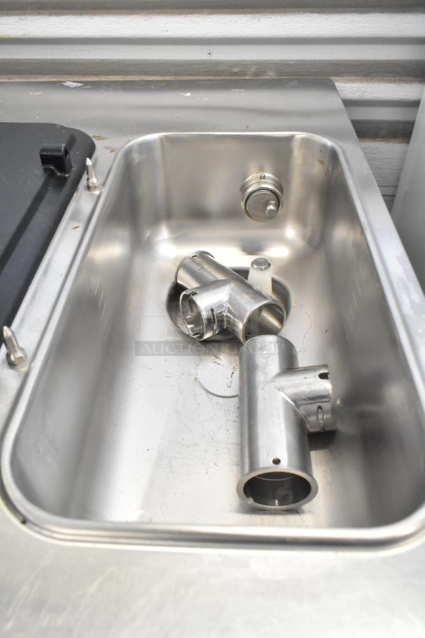 Stainless steel components for Taylor C712-33 ice cream machine in basin, showcasing its durable construction.