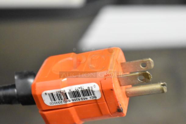 Close-up of an orange power plug with visible barcode label, related to Traulsen G31010 commercial freezer.