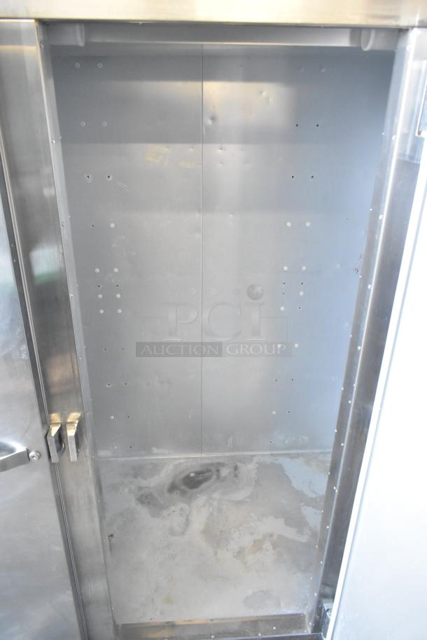 Traulsen G31010 commercial 3-door reach-in freezer, stainless steel interior. 115 volts, 1 phase. Visible wear on interior.