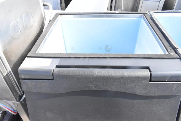 Commercial ice bin with a black exterior and blue interior. Appears in good condition. Text "CMA" is visible on adjacent equipment.