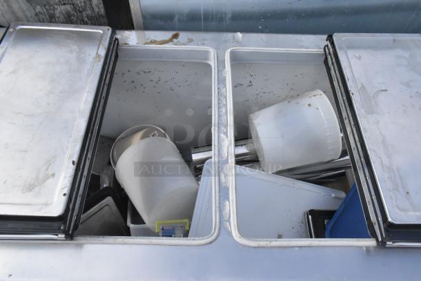 Kelvinator commercial chest freezer with opened lids, commercial casters; shows interior and some surface marks.