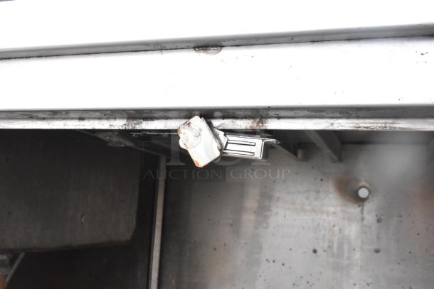 Commercial 3 bay sink featuring an over shelf and 3 doors. Visible wear suggests moderate use. Ideal for restaurant settings.