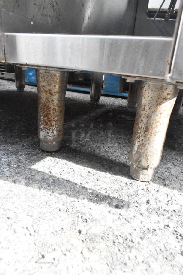 Commercial single bay sink with rusted legs and lower storage door. Stainless steel construction, used condition.