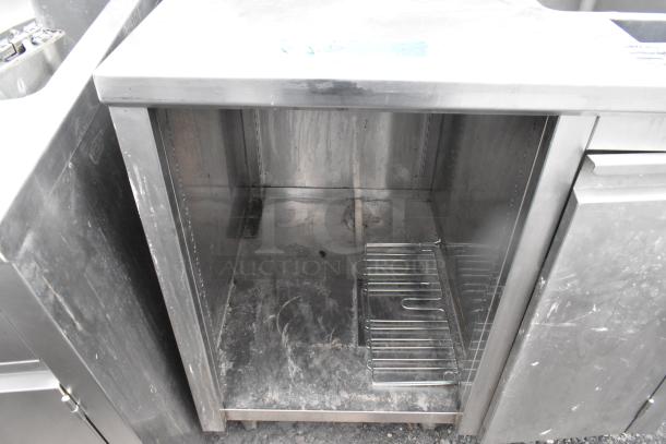 Commercial single bay sink with under shelf, stainless steel, visible wear, integrated shelf for storage, ideal for kitchen use.