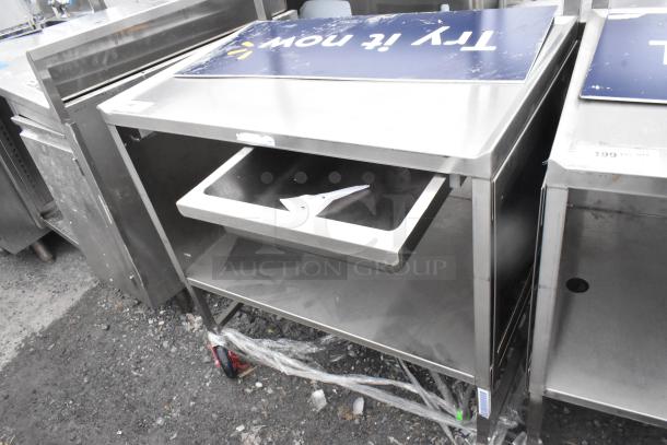 Commercial table with drawer, under shelf, and casters. Stainless steel finish. Visible wear on surfaces. Tags indicate "Try It Now."