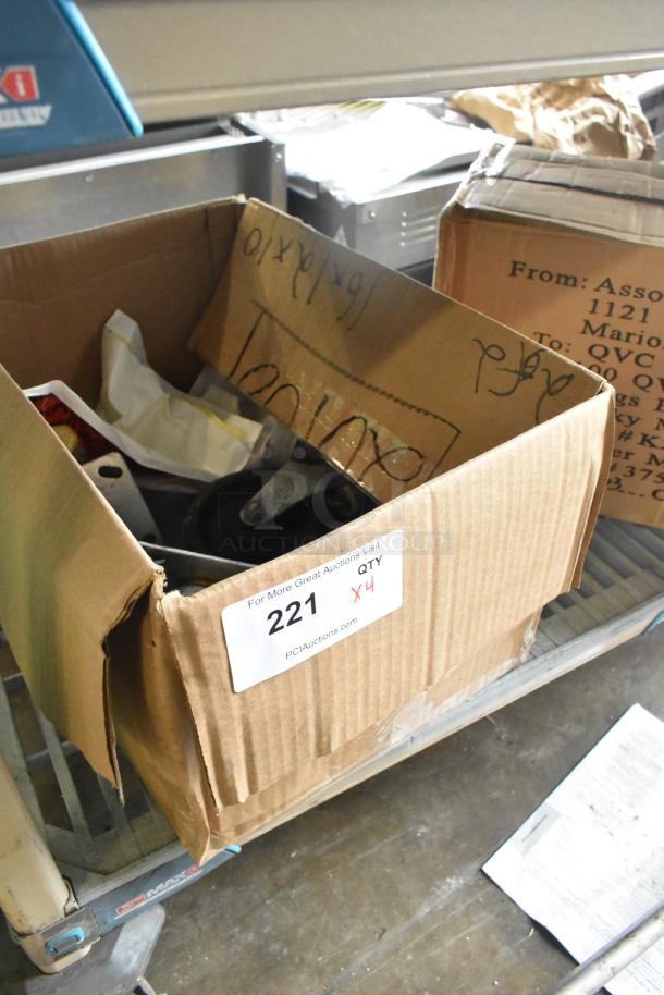 Lot of 4 commercial casters in a cardboard box. Box label shows "221 X4" from PCIAuctions. Condition appears used.