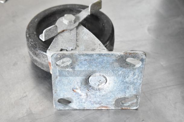 Lot of 4 commercial casters, features heavy-duty black wheels and metal mounting plates with visible wear.