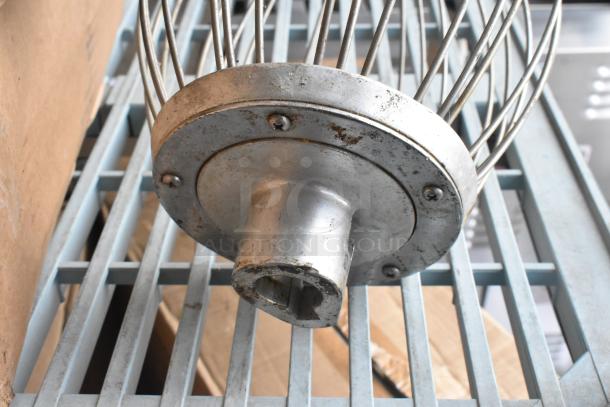 Commercial whisk attachment for Hobart mixer, metal construction, used condition, visible wear on base and cage.