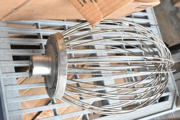 Commercial whisk attachment for Hobart mixer, stainless steel, in used condition, fitting hub visible. Ideal for large-scale mixing.