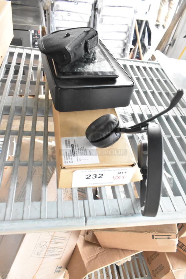 Assorted items including a tablet with case, XG2v2-P box, and over-ear headphones displayed on a metal shelf.