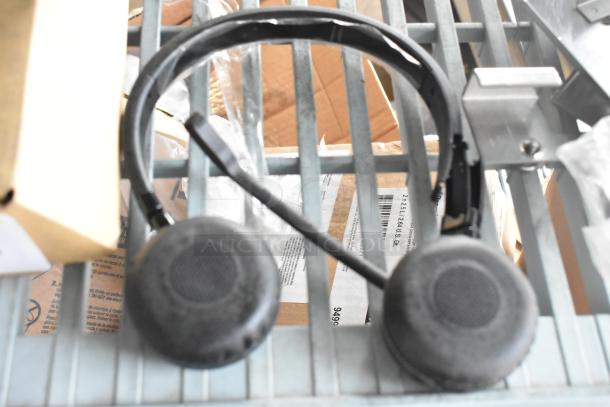 Headphones on metal grid. Black over-ear design. Condition appears used. Part of auction lot with tablet and XG2v2-P.