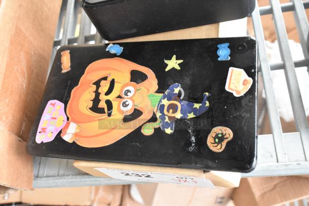 Tablet with Halloween-themed stickers, visible wear, part of 5-item auction lot including XG2v2-P and headphones.
