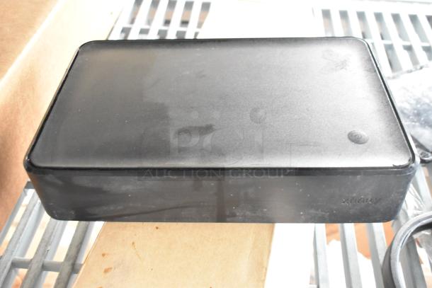 Xfinity XG2v2-P cable box, black, minor wear, vented top, auction lot with headphones and tablet.