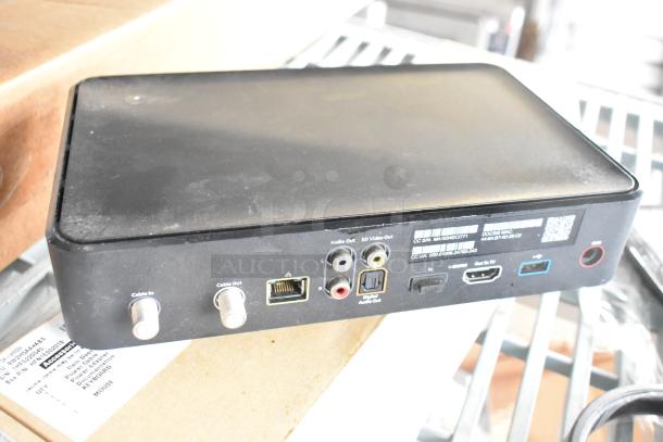 Black XG2v2-P device with cable inputs, audio out ports, HDMI, and serial number label on the back panel.