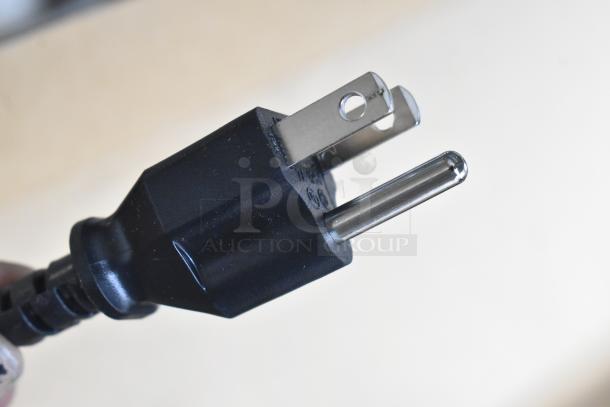 Close-up of a standard black power plug with two metal prongs in excellent condition, part of a 5-item auction bundle.