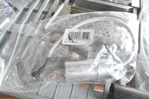 Bag containing a part labeled "17828021RC" with attached hose, barcode, and connector, part of a 9-item auction lot.