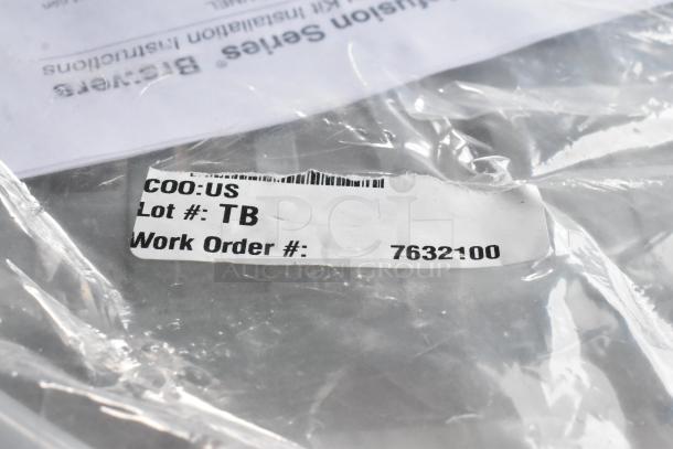 Clear plastic bag containing various items with a visible label showing "COO: US," "Lot #: TB," and "Work Order #: 7632100."