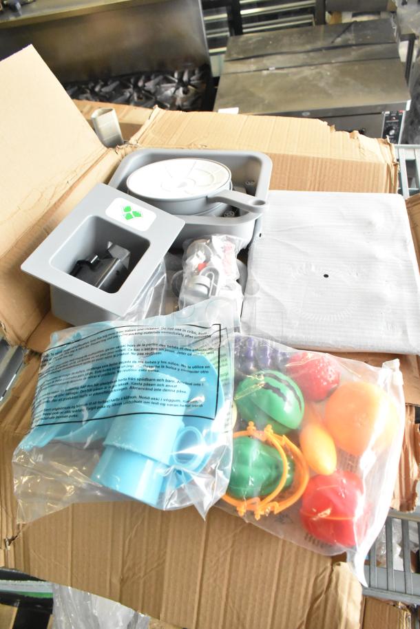 Lot of kids kitchen set accessories including velcro cut produce, skillet, and plastic screws. Items are new in packaging.