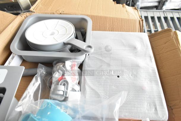 Lot of various kids' kitchen set accessories including a grey skillet, Velcro cut produce, and plastic screws in box.