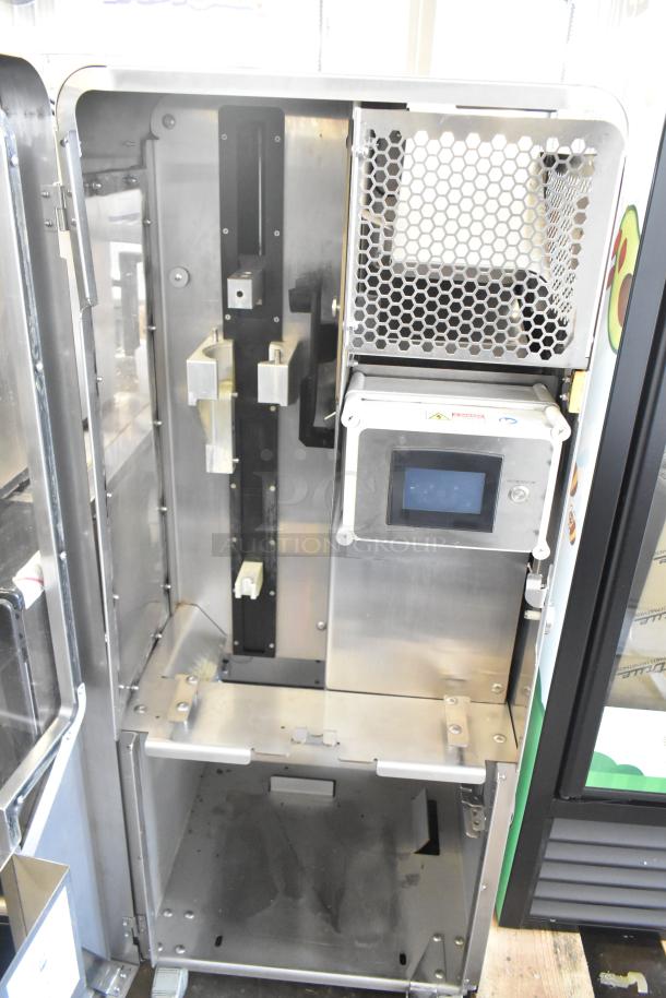 JBT 2ND-GEN-MFJ-HE Fresh N Squeeze commercial citrus juicer interior with a control panel and metal components, on casters.