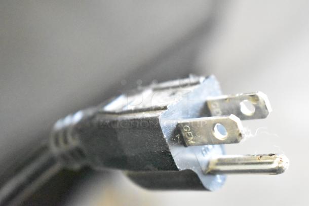 Close-up of a standard electrical plug with visible prongs and markings, part of the 2022 Scotsman NH0622A-1B ice head system.