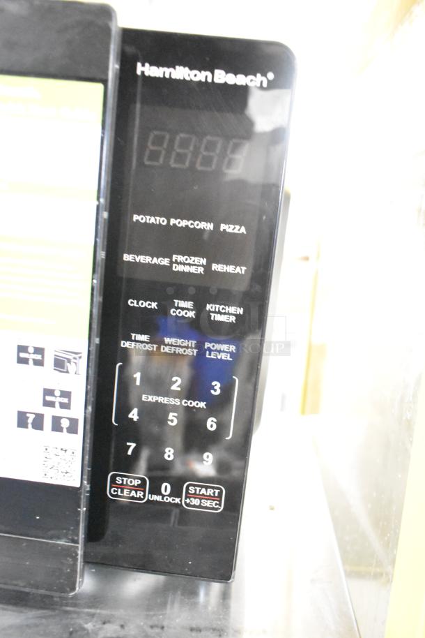 Hamilton Beach HB8436127995-02 countertop microwave with digital display and keypad. Features presets and defrost options. 120V.