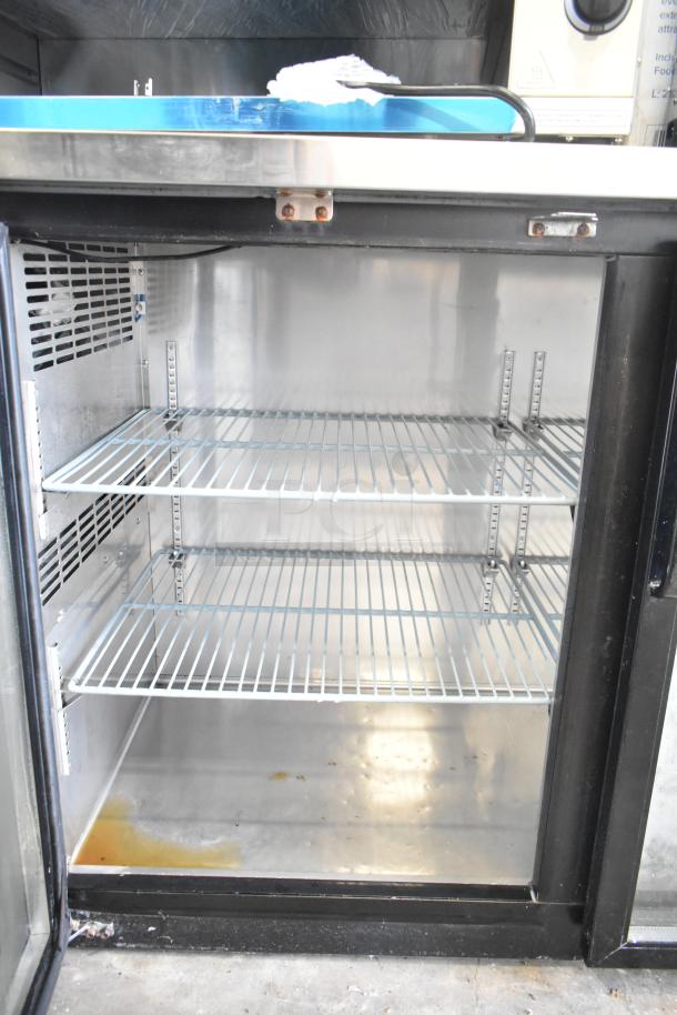 Avantco UBB-24-60G commercial 2 door back bar cooler, interior view showing empty wire racks, minor wear on shelves.