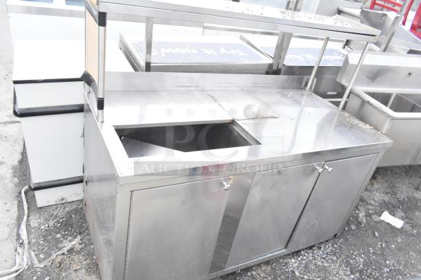 Commercial counter with cut-out, over shelf, and three doors, stainless steel, used condition, suitable for kitchen use.