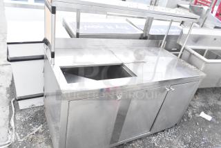 Commercial counter with cut-out, over shelf, and three doors, stainless steel, used condition, suitable for kitchen use.