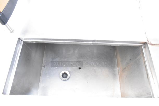 Commercial kitchen counter with cut-out sink, over shelf, and three doors. Stainless steel, used condition.