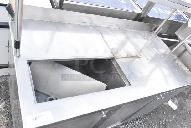 Stainless steel commercial counter with cut-out, over shelf, and three locking doors; used condition with visible wear.