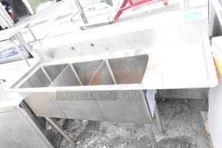 Commercial 3 bay stainless steel sink with right side drain board. Features three compartments, sturdy metal legs, and visible wear.