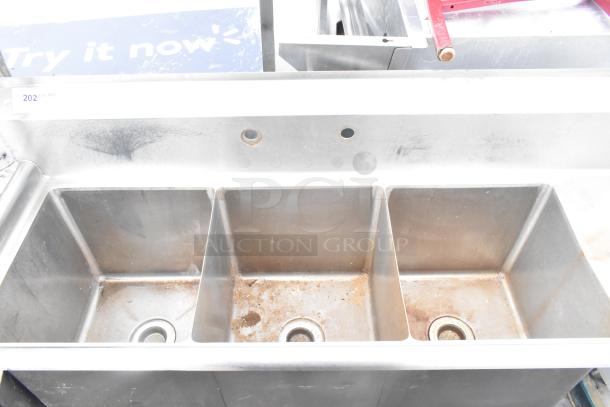 Commercial 3 bay stainless steel sink with right side drain board, visible wear and rust, suitable for heavy-duty use.
