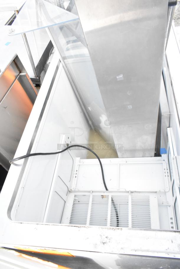 Commercial ice cream dipping cabinet, stainless steel, white interior, good condition, visible electrical cord.