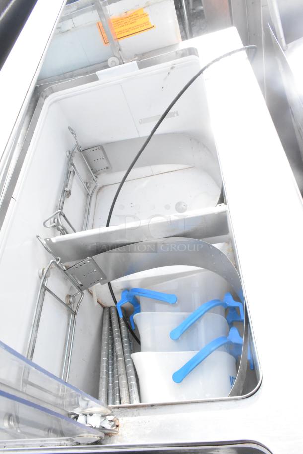 Commercial ice cream dipping cabinet with metal tub collars, open top view; includes tubs and handles, good condition.