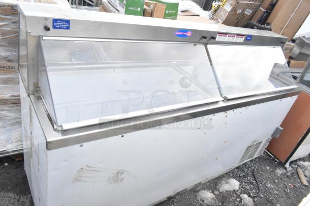 Commercial ice cream dipping cabinet with sliding glass lid, stainless steel frame, and visible exterior wear marks.