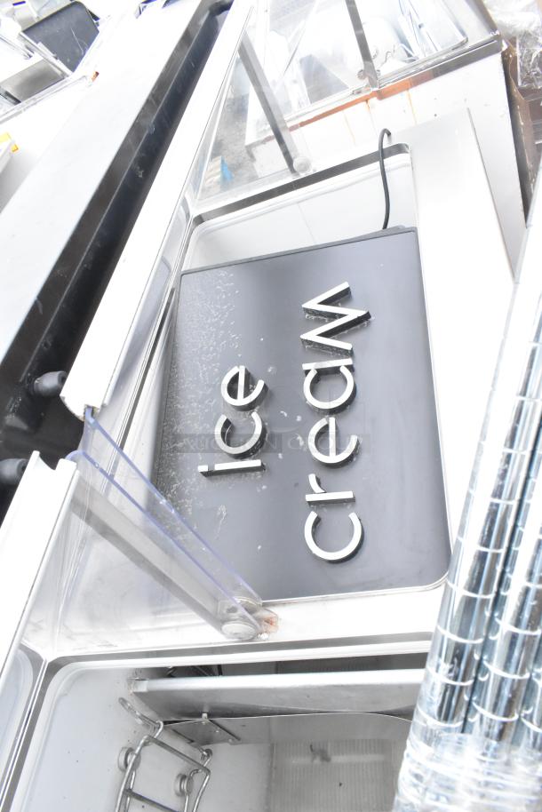 Commercial ice cream dipping cabinet with glass display, metallic interior, and "Ice Cream" lettering. Used condition.