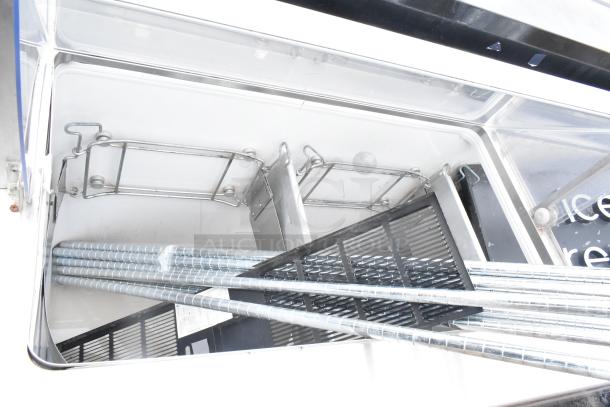 Commercial ice cream dipping cabinet interior, showing racks and metal tubing, clean condition. Ideal for ice cream display.