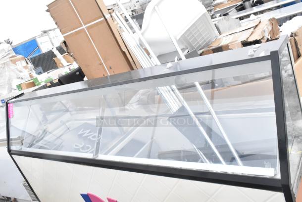Commercial ice cream dipping cabinet with glass front, metal frame, and storage area. Appears in used condition.